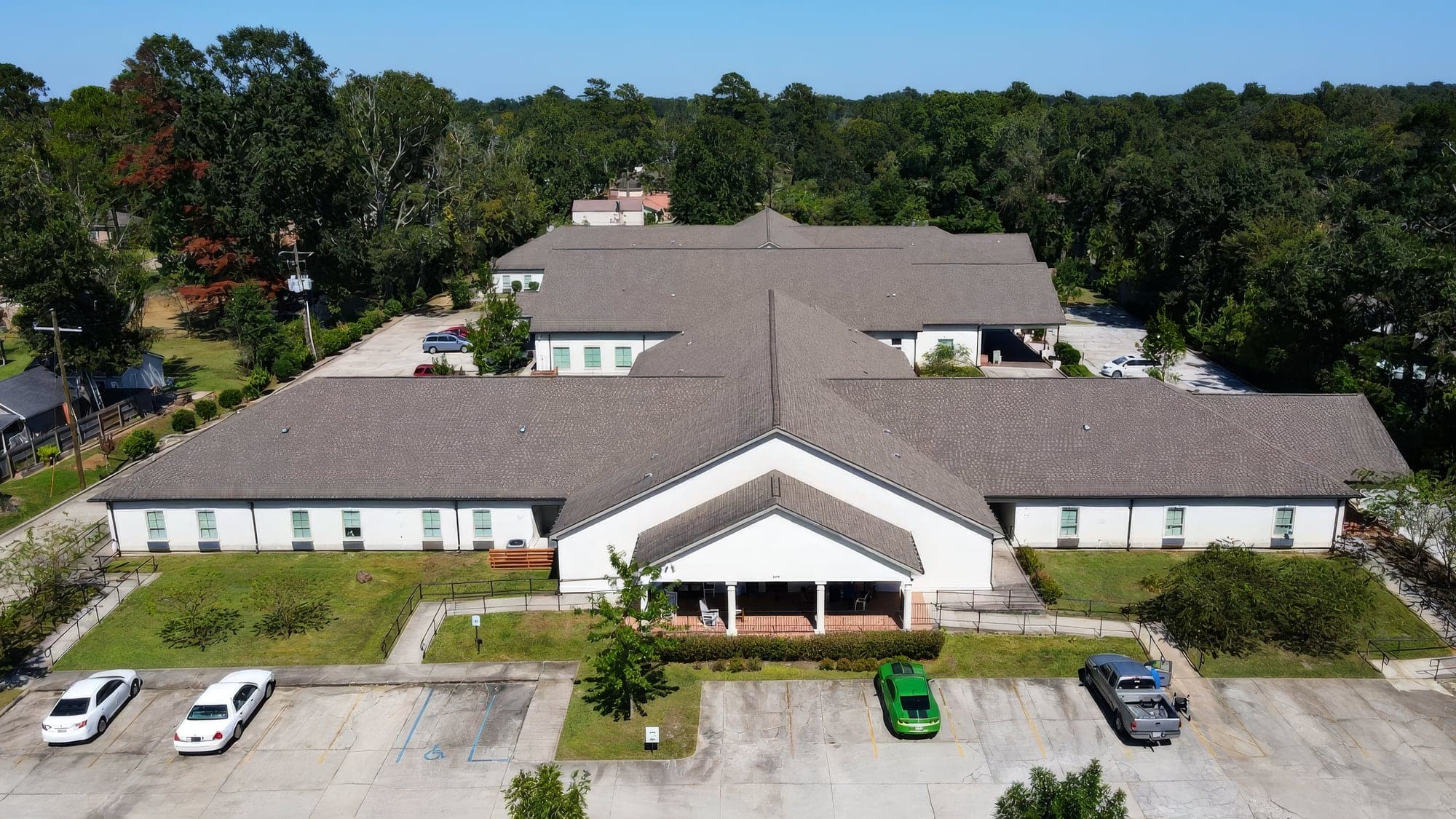Aerial view of a church campus with mowed grounds and a pond